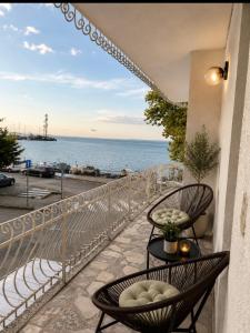 a balcony with two chairs and a view of the ocean at Морски бряг in Pomorie