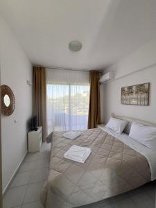 a bedroom with a large bed and a window at Ivory Serenity in Theologos +83 photos