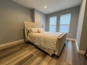 a bedroom with a bed with a headboard and two windows at Ben house in Baltimore +3 photos