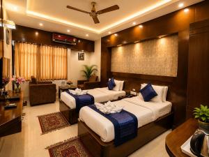 a hotel room with two beds and a living room at Hotel Orion in Bhadrak +31 photos