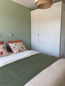 a bedroom with a bed with a white cabinet at Apartament VerdeMar in Rowy