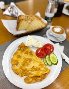 a white plate with an omelet and tomatoes and bread at Riverside Rooms Klos in Klos +64 photos