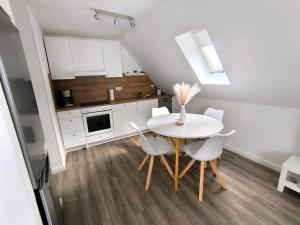 a small kitchen with a white table and chairs at Ferienwohnung Heide in Walsrode