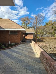 a brick house with a brick walkway at House Sawubona in Kroonstad