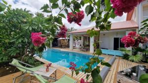 a villa with a swimming pool and flowers at VILLA CAP détente et SPA in Saint-Louis
