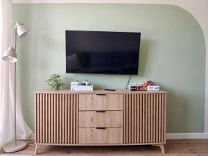 a television on top of a wooden cabinet in a living room at Apartament VerdeMar in Rowy
