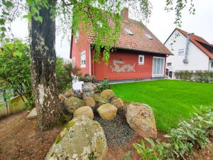 a house with a tree and rocks in the yard at Ferienwohnung Heide in Walsrode