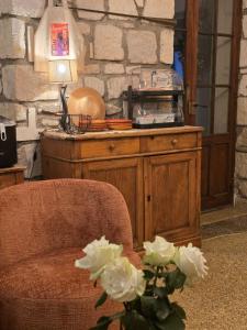 a room with a chair and a table with flowers at Hôtel Le Colbert in Avignon