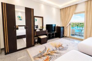 a bedroom with a mirror and a bed and a television at Blue Lotus Nile Suites Hotel Aswan in Aswan