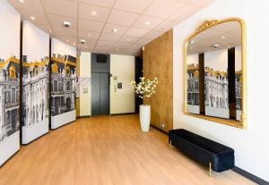 a room with a large mirror and a black couch at B&B HOTEL Versailles Le Chesnay in Le Chesnay