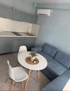 a living room with a couch and a table and chairs at Апартамент Морски бряг in Pomorie