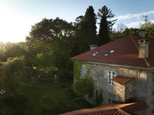 an old stone house with a red roof at Hotel Pazo de Bieite in Boimorto
