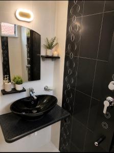 a bathroom with a black sink and a shower at Апартамент Морски бряг in Pomorie