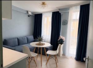 a living room with a blue couch and a table at Апартамент Морски бряг in Pomorie