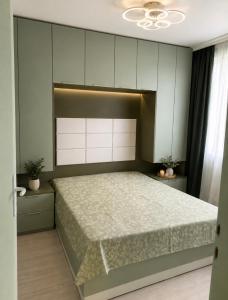 a bedroom with a large bed and white cabinets at Апартамент Морски бряг in Pomorie