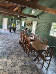 a dining room with a wooden table and chairs at Recanto Vila Madalena in Caçapava
