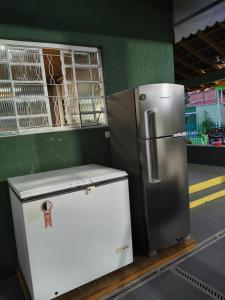 a refrigerator and a freezer sitting next to a wall at Recanto Vila Madalena in Caçapava