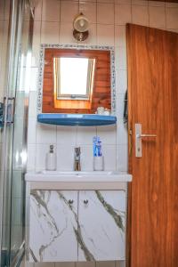 a bathroom with a sink and a mirror at Németh Apartman in Kisapáti +47 photos