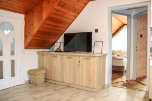 a living room with a television on a wooden cabinet at Németh Apartman in Kisapáti