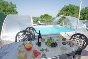 a table with food and wine next to a swimming pool at Németh Apartman in Kisapáti