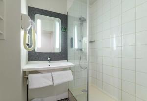 a white bathroom with a sink and a mirror at B&B HOTEL Versailles Le Chesnay in Le Chesnay +15 photos