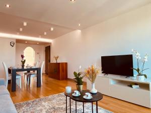 a living room with a television and a dining room at Anna's Cozy Nest a Udine in Udine