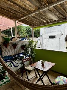a hammock in a room with a table at Hostel New Ipanema in Rio de Janeiro
