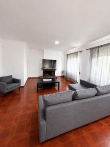 a living room with a couch and a television at Varanda do Coura in Caminha