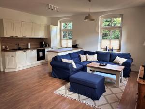 a living room with a blue couch and a table at Alte Schule Rietz in Treuenbrietzen