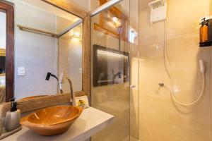 a bathroom with a wooden bowl sink and a shower at Suíte Charmosa na Mucugê - Café da manhã opcional - Conforto e Localização Perfeita in Porto Seguro +78 photos