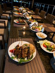 a long table with plates of food on it at Blue Lotus Nile Suites Hotel Aswan in Aswan