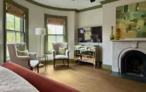 a bedroom with a fireplace and two chairs and a bed at Clarendon Square in Boston