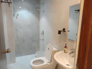 a bathroom with a toilet and a sink and a shower at Hotel Tals Hytek in Hyderabad