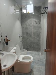 a bathroom with a toilet and a sink and a shower at Hotel Tals Hytek in Hyderabad