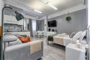 a bedroom with a bed and a couch and a tv at Flow Urban Living by DiffeRent in Ferrara