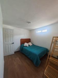 ein Schlafzimmer mit einem Bett mit grüner Bettdecke und einem Fenster in der Unterkunft Casona Don Nilo in Morelia
