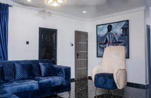 a living room with a blue couch and a chair at Smile Apartment in Ilishan