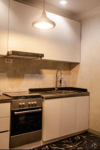 a kitchen with a stove and a sink at Smile Apartment in Ilishan