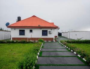 a house with a red roof and a walkway at Smile Apartment in Ilishan