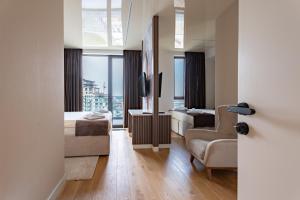 a hotel room with a bed and a chair and a window at Hotel Eterna Hill Rooftop in Sajmište