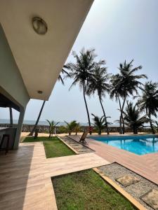 a house with a swimming pool and palm trees at Shadamaltess in Azuretti