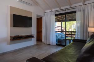 a living room with a tv and a couch at Ville Saint Germain Apart Hotel & Spa in Carilo