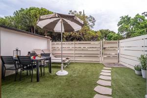 a patio with an umbrella and a table and chairs at NOVELLA DEL MAR prima fila dal mare in Grottammare