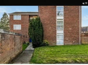 a brick building with a tree in front of it at Cozy Flat in Steyning