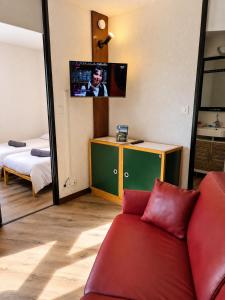a living room with a red couch and a mirror at L'évasion montagnarde - résidence loisirs - garage in Lélex