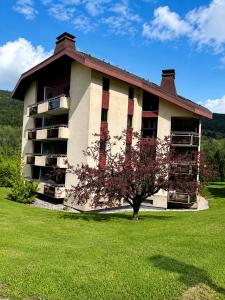 a building with a tree in front of it at L'évasion montagnarde - résidence loisirs - garage in Lélex