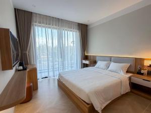 a bedroom with a large bed and a large window at Sơn Trà 668 in Sa Vi Xom