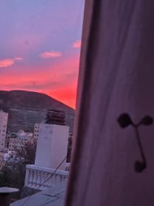 a view of a sunset from a window of a building at Casa LIDIA Hostel in Comodoro Rivadavia