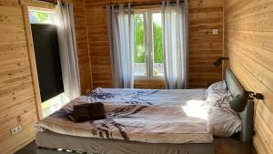 a bed in a wooden room with a window at Hagens Cottage in Wanfried