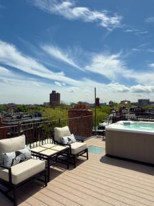 a balcony with chairs and a hot tub on a roof at Clarendon Square in Boston +14 photos